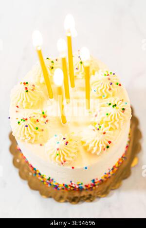 Torta di compleanno con candele accese sopra la testa Foto Stock