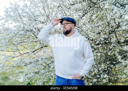 Uomo sicuro ed elegante in piedi nel campo di colza durante la primavera Foto Stock
