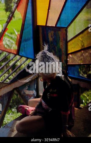 Donna matura con dreadlock seduto nel padiglione dell'arte, Canggu, Bali Foto Stock
