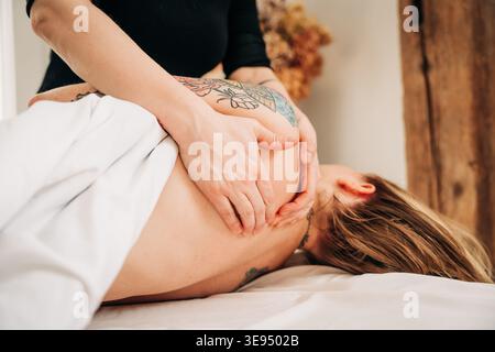 Massaggiatore che effettua un massaggio spalle e collo Foto Stock