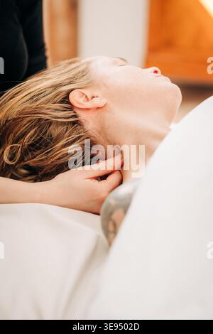 Donna che riceve una rilassante terapia con massaggio al collo e benessere Foto Stock