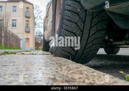 Lo pneumatico dell'auto si trova su un marciapiede Foto Stock