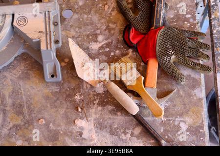 Alla fine della giornata di un commerciante nel settore delle costruzioni, producendo un contrasto di consistenze su un tavolo di cavalletto per muratori. Foto Stock