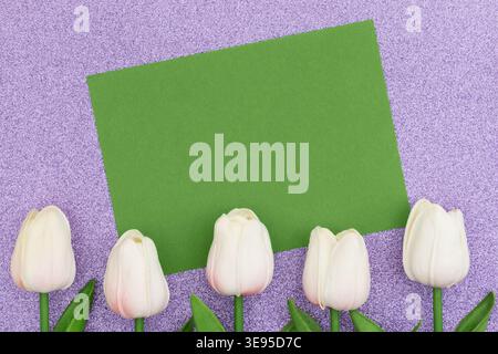 Biglietto d'auguri verde vuoto con tulipani bianchi su glitter viola, ideale per messaggi primaverili, inviti e concetti di design a tema floreale Foto Stock