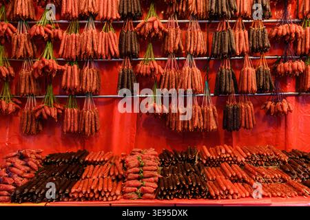 Stringhe di salsicce cinesi di lap cheong, una salsiccia di maiale salata e dolce, un punto fermo della cucina cantonese, appesa in una bancarella di mercato a Singapore. Foto Stock