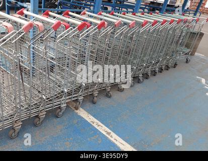 I carrelli della spesa vuoti sono in fila. Carrelli in metallo vicino a un supermercato. Foto Stock