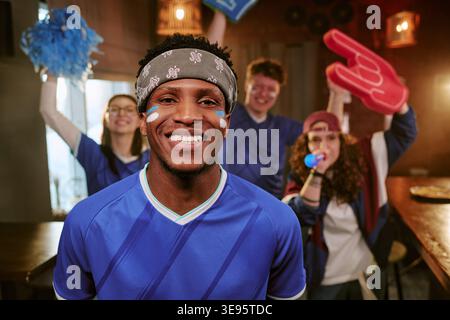 Ritratto di Black Man che esultano con gli amici durante la visione sportiva Foto Stock