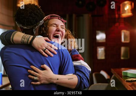 Black Man e Adult Woman abbracciano Joyful Reunion indoor Foto Stock