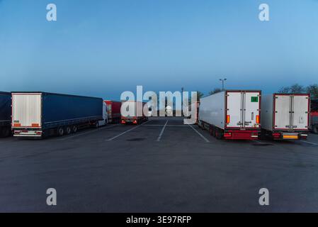 Camion parcheggiati in un ampio parcheggio nelle prime ore del giorno Foto Stock