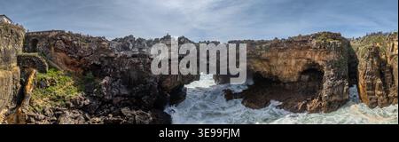 Vista aerea dell'arco naturale di Boca do Inferno con onde atlantiche che si infrangono contro aspre scogliere calcaree Cascais, Lisboa, Portogallo. Foto Stock