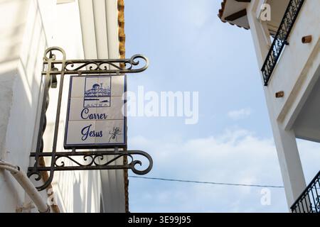 Cartello stradale ad Altea, Spagna, con i dettagli di Carrer Jesus e della città, invitando i turisti a esplorare il fascino della città vecchia durante le vacanze in famiglia Foto Stock