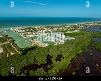 Vista aerea della penisola dello Yucatan con un piccolo porticciolo, fitte mangrovie verdi e spiagge di sabbia bianca lungo la costa turchese di Sisal, Yucata Foto Stock