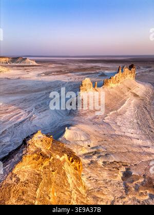Vista aerea delle formazioni rocciose calcaree di Bozhira e delle bianche scogliere nel paesaggio desertico con una persona in piedi su una cresta al tramonto nel distretto di Karakiya Foto Stock