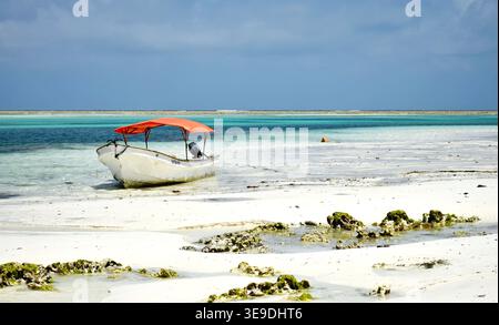 Mare tropicale con una vecchia barca da pesca solitaria sull'isola di Zanzibar, Tanzania Foto Stock
