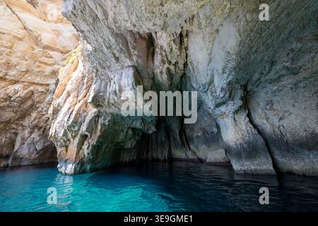 All'interno della grotta marina della Grotta Azzurra vicino a Qrendi, Malta, mostra aspre pareti calcaree e acque turchesi del Mediterraneo con ombre profonde. Foto Stock