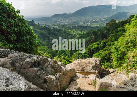 Punto panoramico roccioso che si affaccia sulla lussureggiante valle della giungla e sul mare lontano vicino alla cascata di Samui in Thailandia Foto Stock