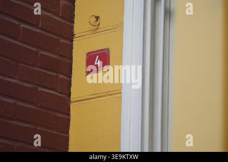 Porta numero quattro su un edificio in una strada cittadina Foto Stock