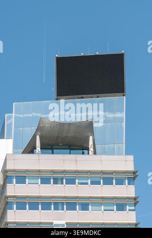 Edificio moderno con grande cartellone bianco contro il cielo blu per spazi pubblicitari. Foto Stock