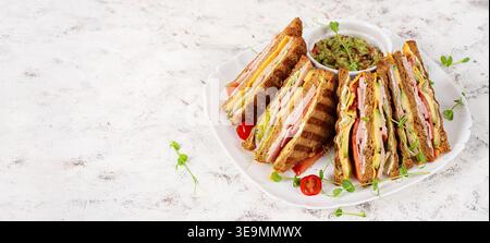 Club sandwich con guacamole e verdure fresche su piatto bianco Foto Stock