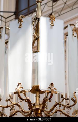 Primo piano di un elegante lampadario con dettagli di illuminazione decorativi in interni architettonici vintage. Foto Stock