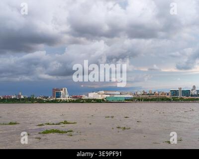 Vista sul lungomare di Malecon del Rio a Barranquilla, Colombia, con skyline urbano, paesaggio fluviale e un suggestivo cielo nuvoloso, che mette in risalto lo stile moderno Foto Stock