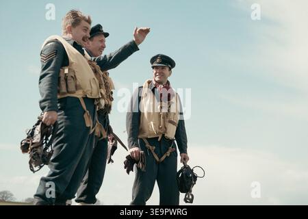 Tre piloti della RAF nella rievocazione della seconda guerra mondiale indossano giubbotti di salvataggio e cappellini con i picchi, uno rivolto verso il cielo all'aeroporto Sywell, Northamptonshire. Foto Stock
