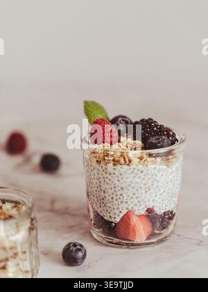 Vista frontale pulita del dolce a strati con bacche e muesli su uno sfondo leggero e minimale Foto Stock