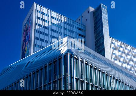 Edifici moderni e alti vicino ad Alexanderplatz nel centro di Berlino, Germania, fotografati contro un cielo azzurro. Architettura dell'ufficio. Foto Stock