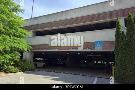 Ingresso al garage di un moderno complesso commerciale e residenziale ad Alpharetta, Georgia, Stati Uniti. Infrastrutture urbane con segnaletica, veicoli Foto Stock