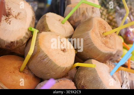 Bevande fresche al cocco sono servite in un ambiente di mercato Foto Stock