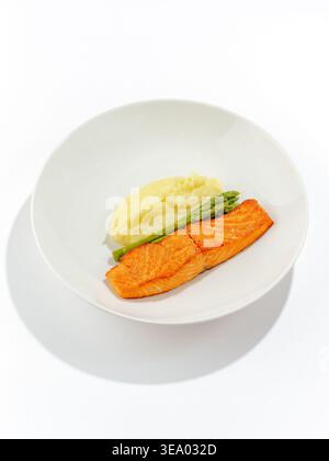 salmone alla griglia con salsa e verdure su un piatto Foto Stock