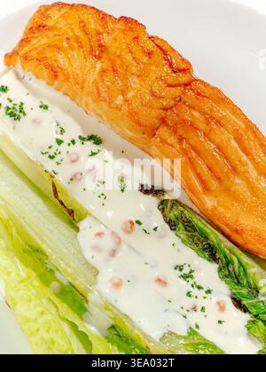 salmone alla griglia con salsa e verdure su un piatto Foto Stock
