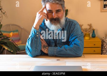 Uomo maturo che dà la priorità al lavoro all'equilibrio della vita e allo stile di vita Foto Stock
