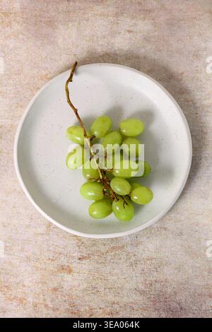 Grappolo di uva verde su un piatto visto dall'alto Foto Stock