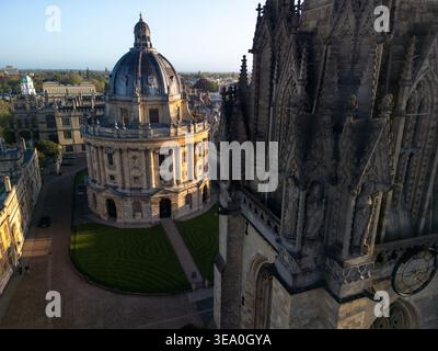 Vista aerea con droni della Radcliffe camera con la pietra gotica della chiesa di Santa Maria Vergine in primo piano, Oxford, Inghilterra Foto Stock