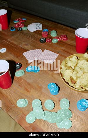 Configurazione del tavolo da poker con carte da gioco chip e snack per feste Foto Stock
