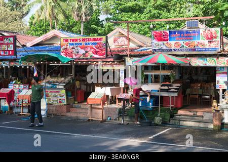 Una vivace fotografia a livello di strada cattura la vivace atmosfera dei ristoranti di pesce locali a Karon, Phuket, Thailandia, il 19 aprile 2026. L'immagine Foto Stock