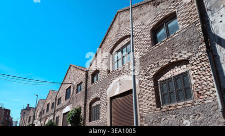 Facciata del vecchio edificio industriale in mattoni sotto Blue Sky Foto Stock