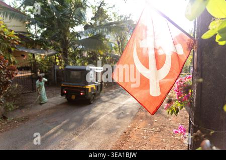 Simboli comunisti per le strade della città di Kannur in Kerala, India, martello e falce su una bandiera rossa, bandiere appese sulle strade, risciò automatico, tuktuk Foto Stock