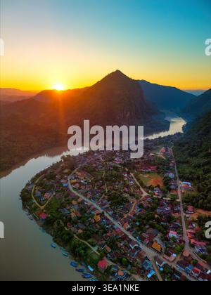 Vista aerea della città di Nong Khiaw annidata lungo il fiume Nam Ou con montagne calcaree e un vibrante tramonto a Nong Khiaw, Luang Prabang Provin Foto Stock