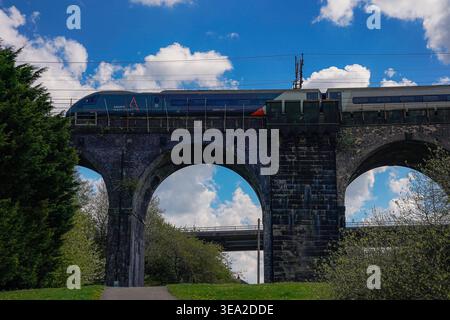 Vista dello storico ponte ferroviario che attraversa il fiume Mersey tra Runcorn e Widnes mentre un treno Avanti West Coast passa lunedì 20 aprile Foto Stock
