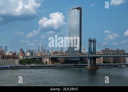 New york, usa 15 agosto 2024. Ponte di Manhattan che attraversa il fiume est con una piazza di manhattan e lo skyline di manhattan che torreggia sul lungomare di brooklyn Foto Stock