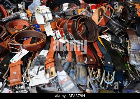 Roma, Italia - 19 aprile 2026: Vista ravvicinata di una banchina del mercato di strada a porta Portese che mostra una grande pila di cinture in pelle. La selezione i Foto Stock