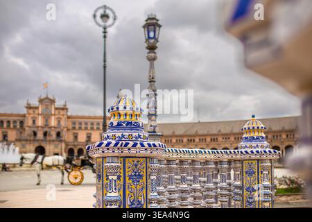Siviglia, Andalusia, Spagna - 12 febbraio 2020: Vista ravvicinata della balaustra in ceramica azulejo ornata e dei lampioni decorativi in Plaza de España, con il Foto Stock