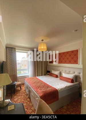 Accogliente camera interna con letto doppio, luce calda ed elegante design classico Foto Stock