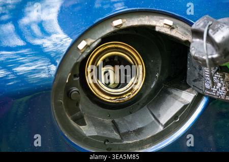 Zurigo, Svizzera, 17 aprile 2026. Primo piano di un collo del bocchettone di rifornimento del carburante aperto per auto senza tappo del serbatoio su un veicolo metallico blu che mostra una composizione metallica interna Foto Stock