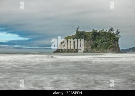 Onde a lunga esposizione che si innalzano sulla costa rocciosa del Parco Nazionale Olimpico sotto le spettacolari nuvole del Nord-Ovest Pacifico Foto Stock