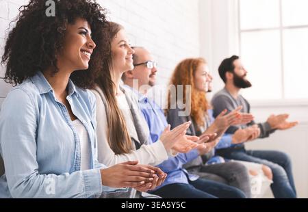 Gruppo di diverse persone battendo le mani alla riunione Foto Stock