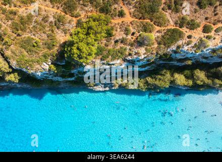 Vista aerea del mare turchese, dei nuotatori e della costa rocciosa Foto Stock