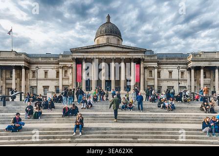 LONDRA - 11 APRILE 2022: Turisti al di fuori della National Gallery a Trafalgar Square, Londra, Inghilterra, Regno Unito. Fondata nel 1824, la Galleria è una delle più munizioni Foto Stock
